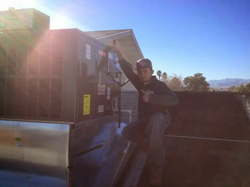 HVAC technician performing AC Tune-Up on a rooftop unit in Farmington Hills